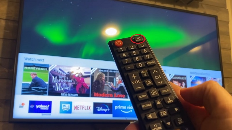 Nhấn vào nút Source (Nguồn) trên remote TV Samsung, kích hoạt chức năng Airplay hoặc phản chiếu màn hình